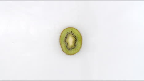 In-slow-motion-water-splashes-pour-water-onto-one-kiwi-on-a-white-background.-Vegetarian-and-Fructorians.